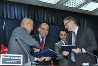 署名を終え握手をする��橋・駐アフガニスタン大使（左）とバルマック・アフガニスタン農村復興開発大臣（中央）とロドリゲスUNDPアフガニスタン事務所長