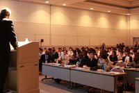 会場には200人以上の若者が集いました。壇上はAUCのハキム博士、客席中央前列に登壇を待つAU-YVCのテフェラ氏（左）、ウガンダ全国NGOフォーラムのカヒイグア氏（中央）、TICADV学生プロジェクトの辻共同代表（右）（C）UNV